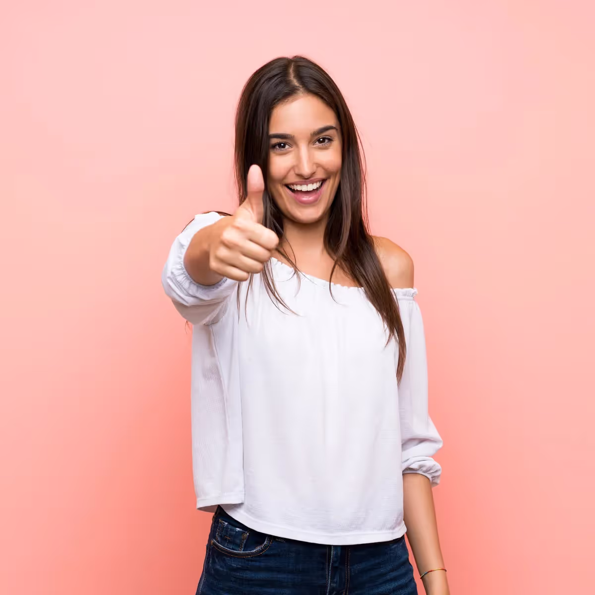 A woman giving a thumbs up on a pink background.